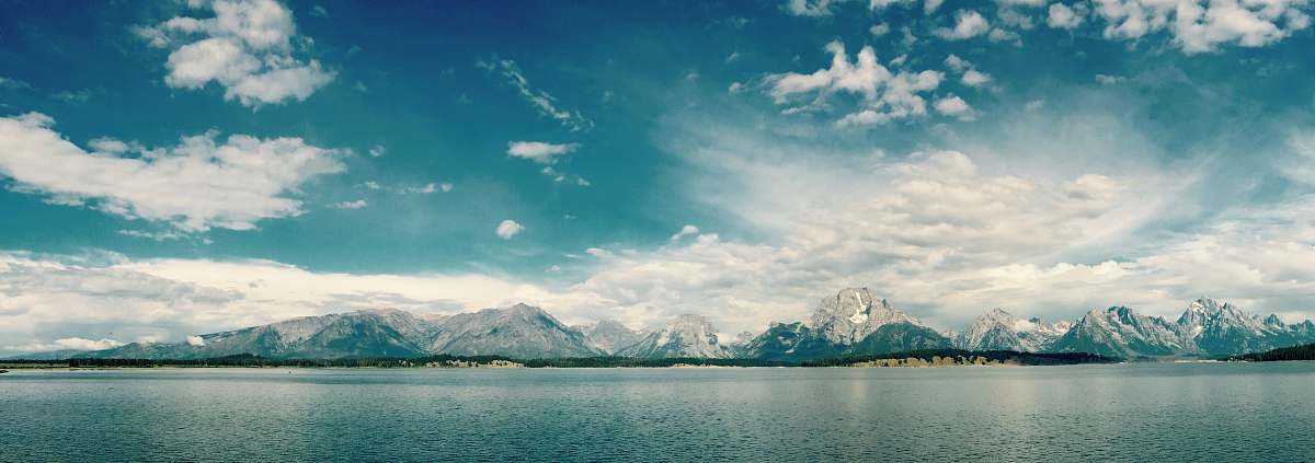 mountain ocean view on cloudy sky during daytime mountains