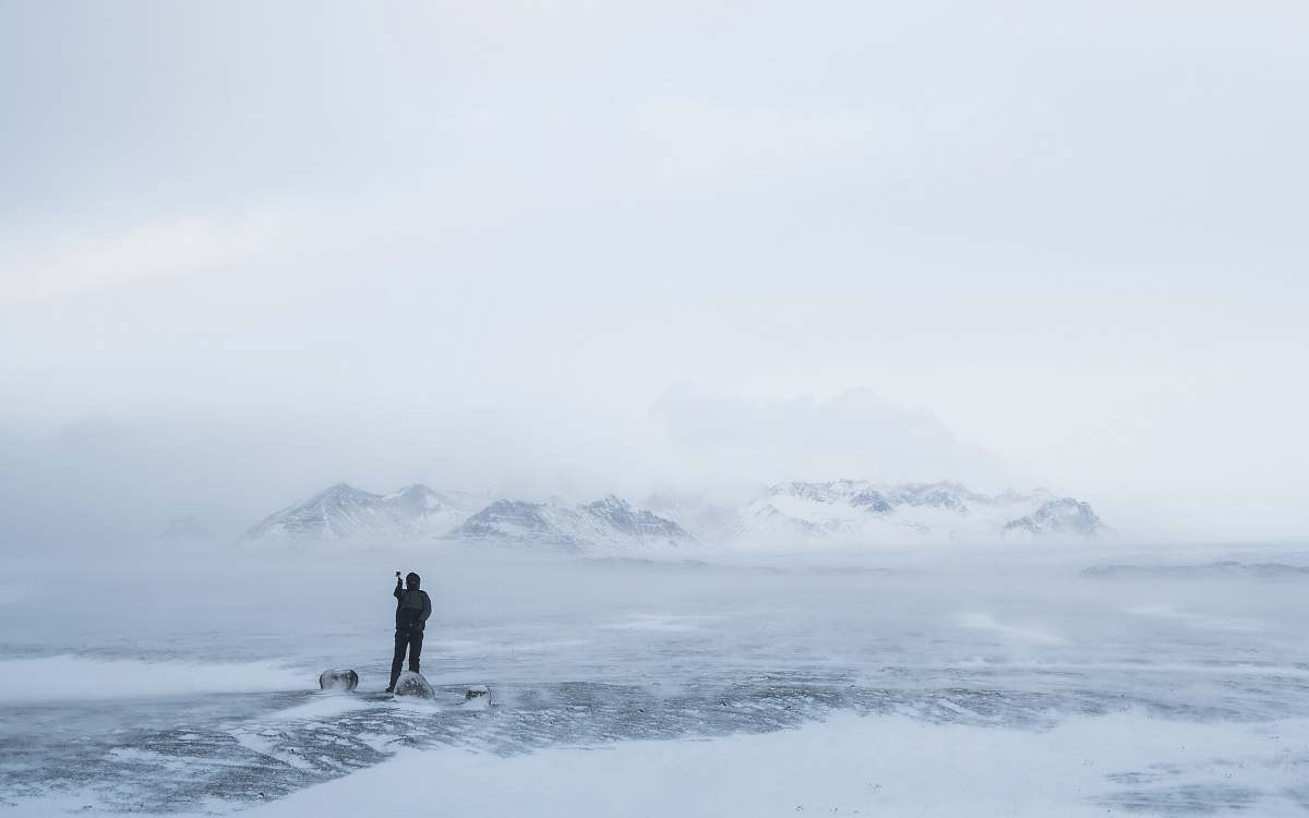 mountain photo of person walking on snow iceland