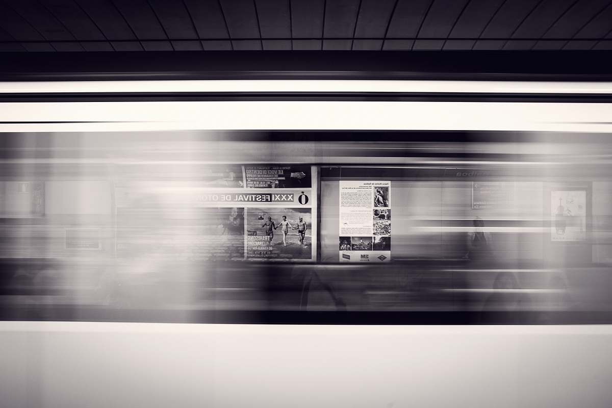 subway A long-exposure shot of a moving subway train and advertisement posters at the station train