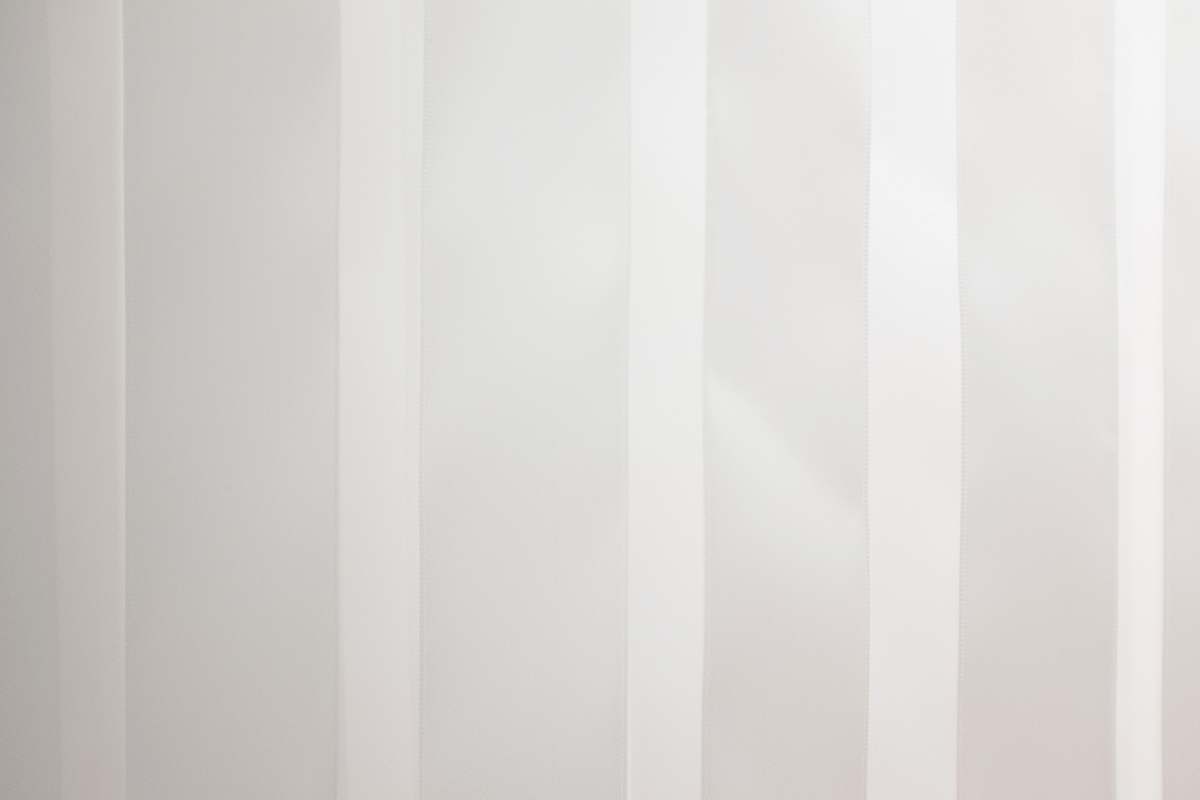 Discover the serene beauty of an elegant white door set against a stylish white wall adorned with vertical stripes. This captivating scene offers a perfect blend of modern minimalism and classic charm, making it an ideal choice for interior design projects, home decor inspiration, or real estate listings. The soft lighting and clean lines provide a tranquil atmosphere, perfect for showcasing residential or commercial spaces that prioritize sophistication and simplicity.