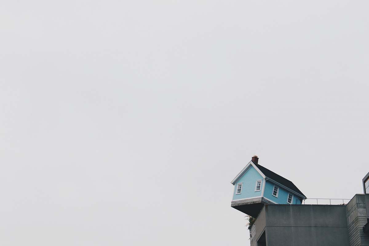house blue concrete storey house on top of building at daytime balance