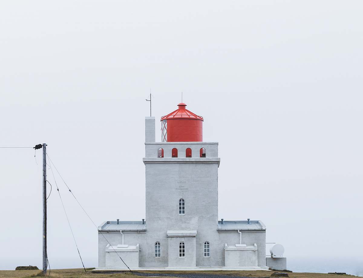 lighthouse building near post at daytime iceland