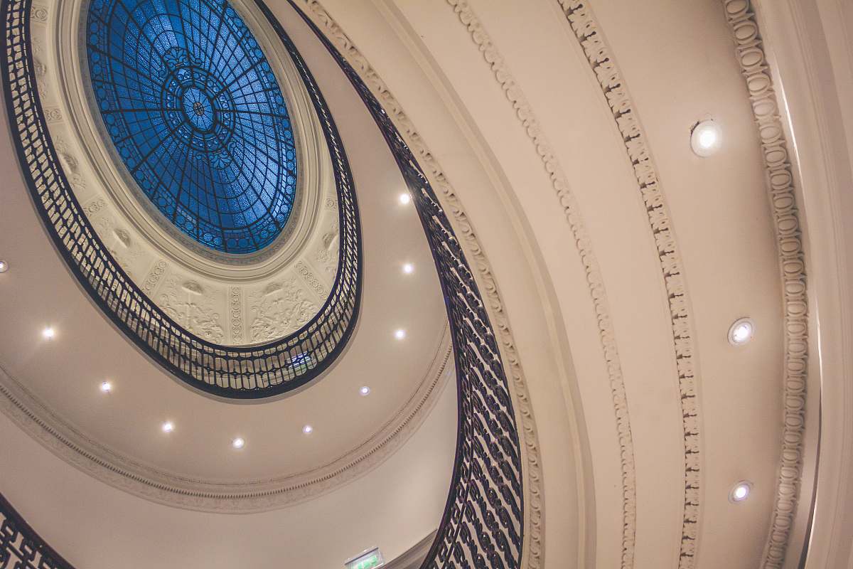 lights low-angle photo of white spiral building glass ceiling