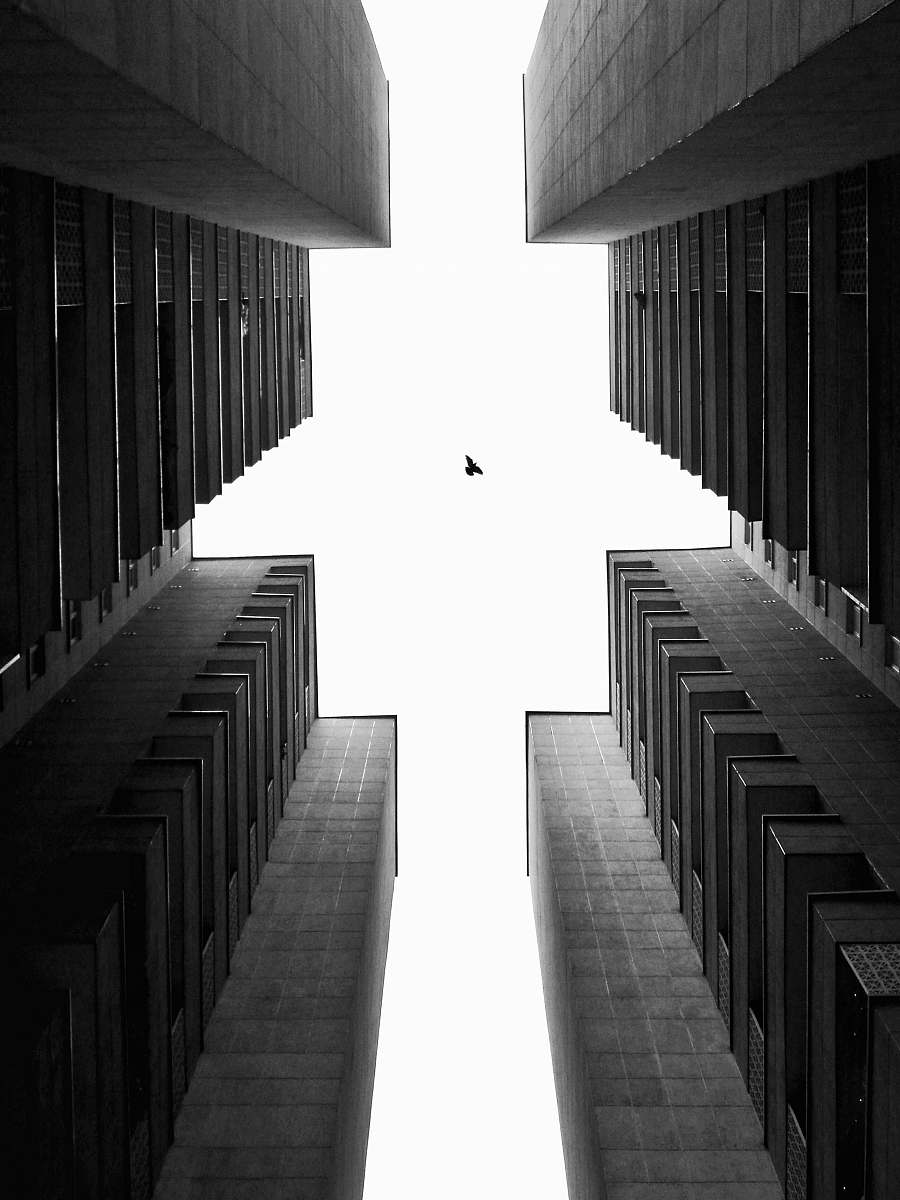 black-and-white low-angle photograph of high-rise building corridor