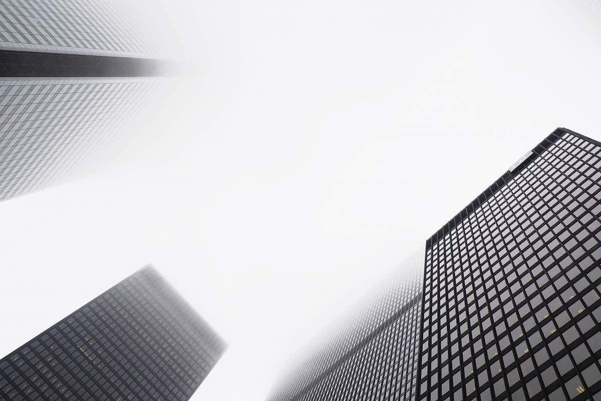Experience the grandeur of urban architecture with this stunning low-angle photograph featuring towering skyscrapers emerging through a blanket of fog. This striking image captures the essence of a modern cityscape, perfect for use in real estate brochures, travel blogs, or architectural presentations. The interplay of light and mist adds a dramatic flair, making it an ideal choice for those seeking to convey the awe-inspiring beauty of metropolitan life.