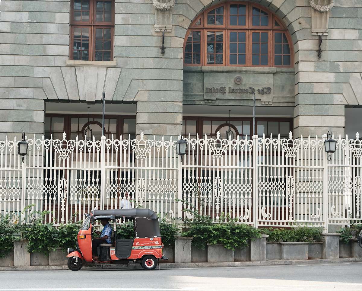 car red auto rickshaw parked in front of concrete structure architecture