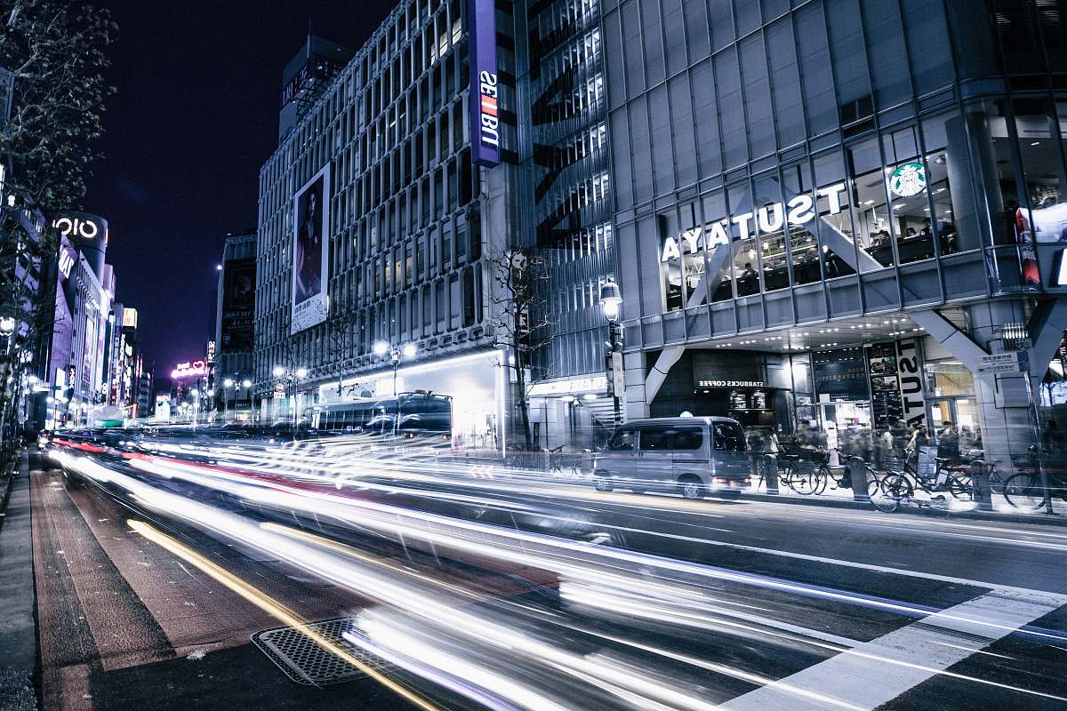 city time-lapse photography of asphalt road near buildings during nighttime dark