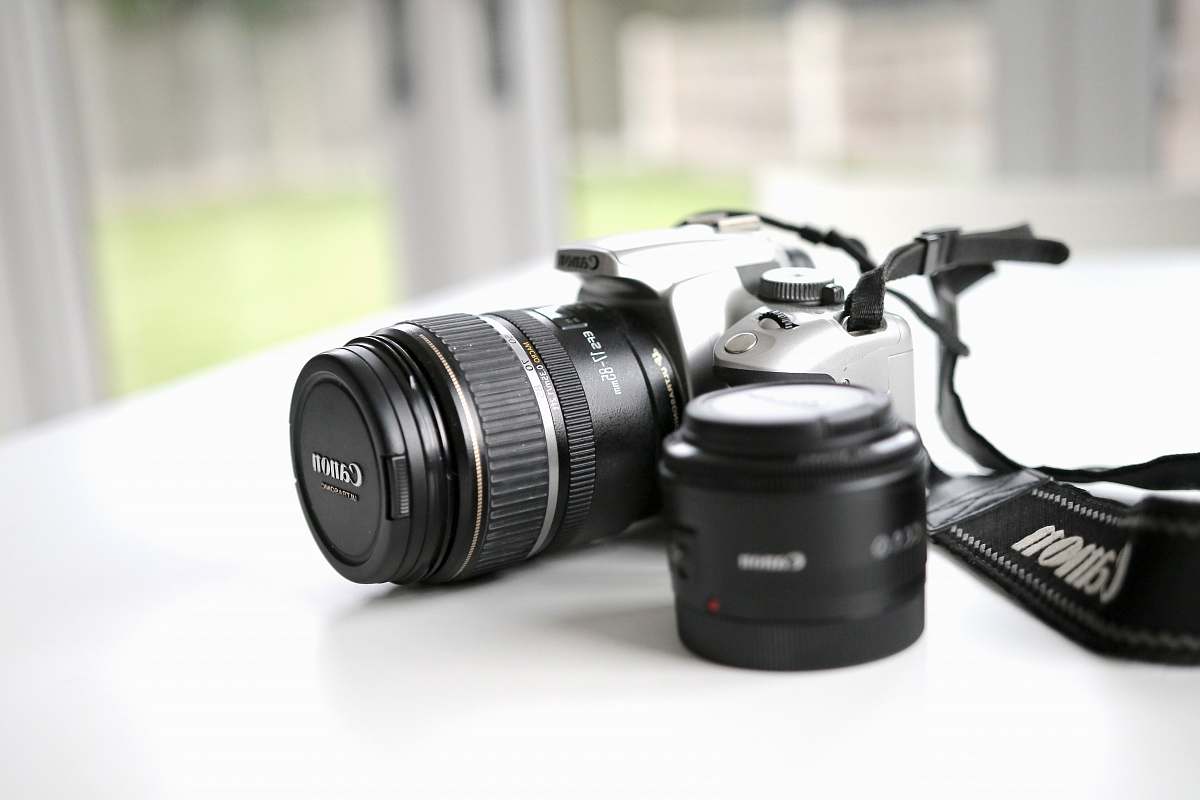 electronics black Canon DSLR camera on white surface canon