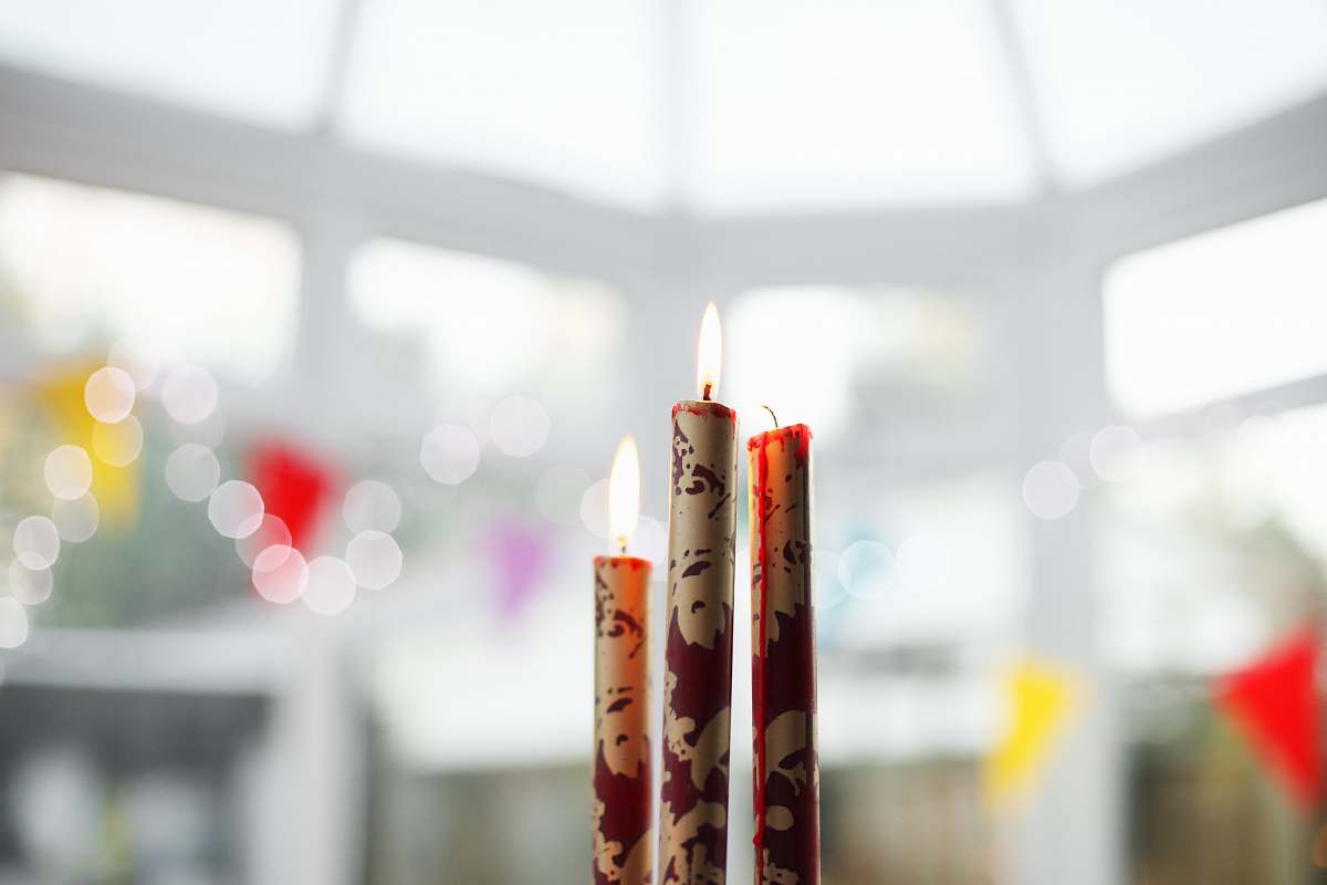 light three brown-and-red candles on top of table interior design