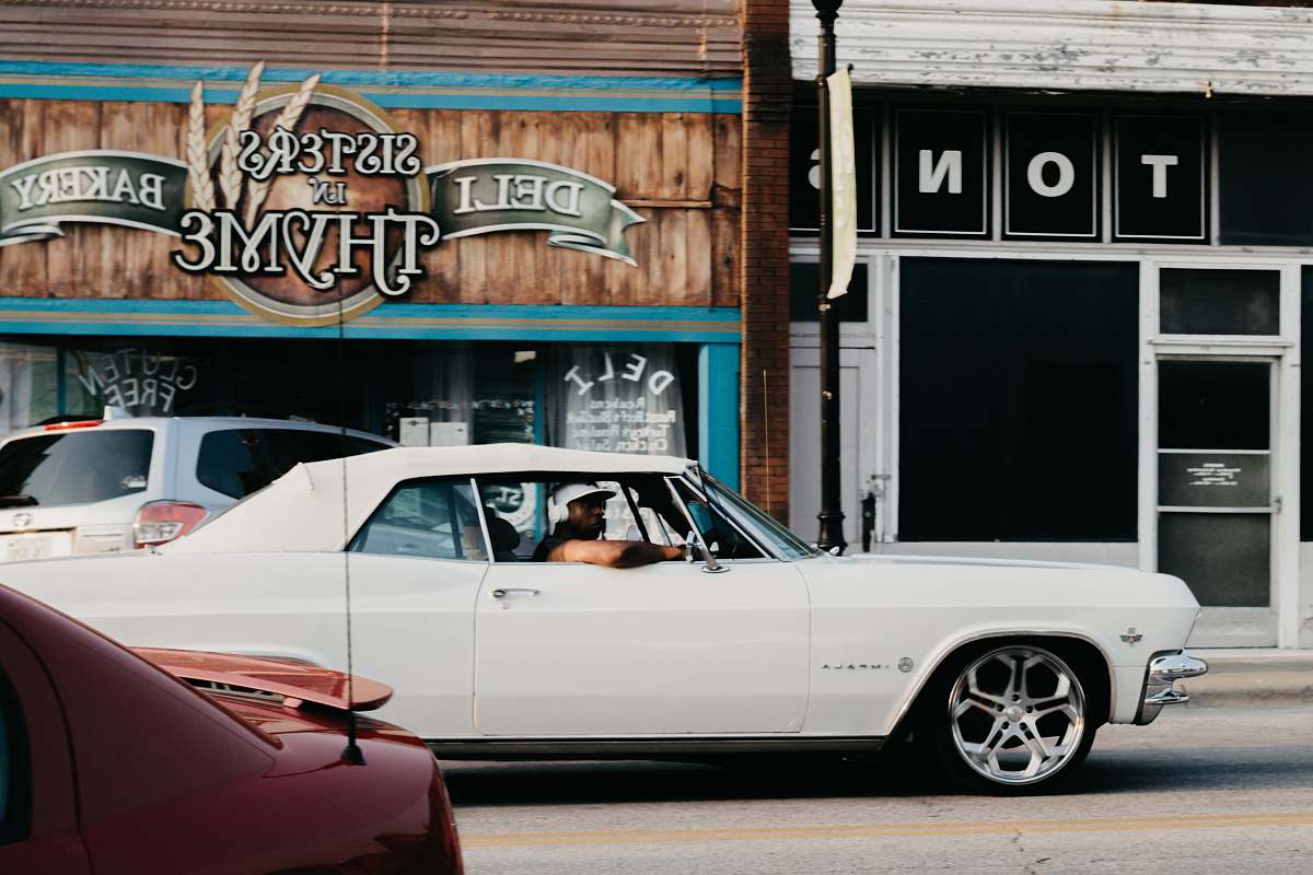 transportation person riding on a white coupe vehicle