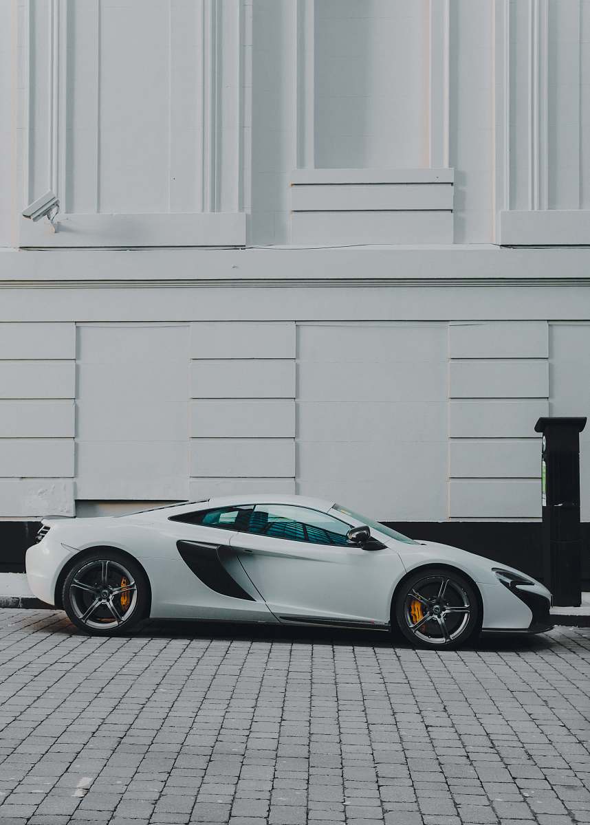vehicle white and black coupe beside white building paint manchester