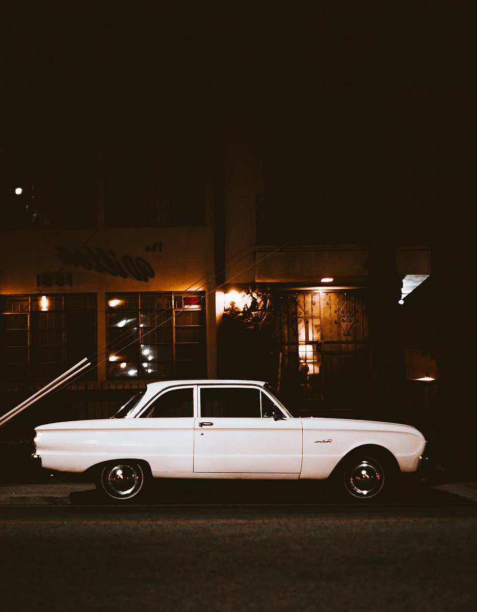 automobile white car parked beside the street sedan