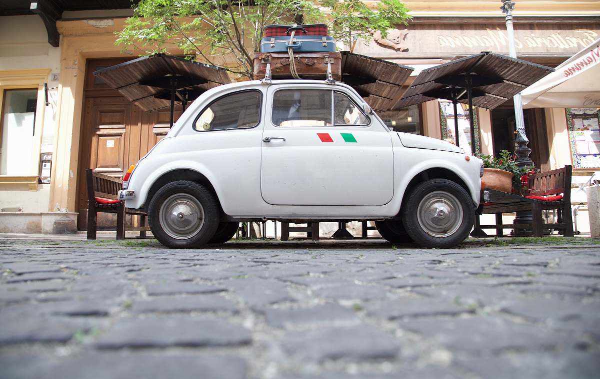 suitcase white coupe parking near building luggage