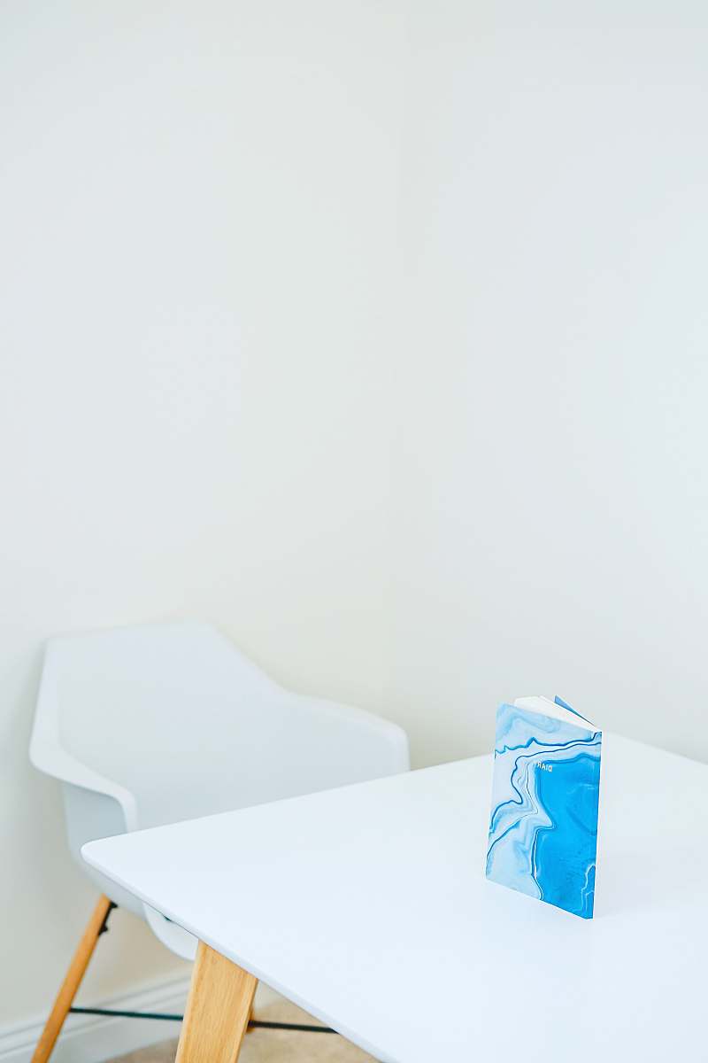 table blue and white hardbound book on white wooden table furniture