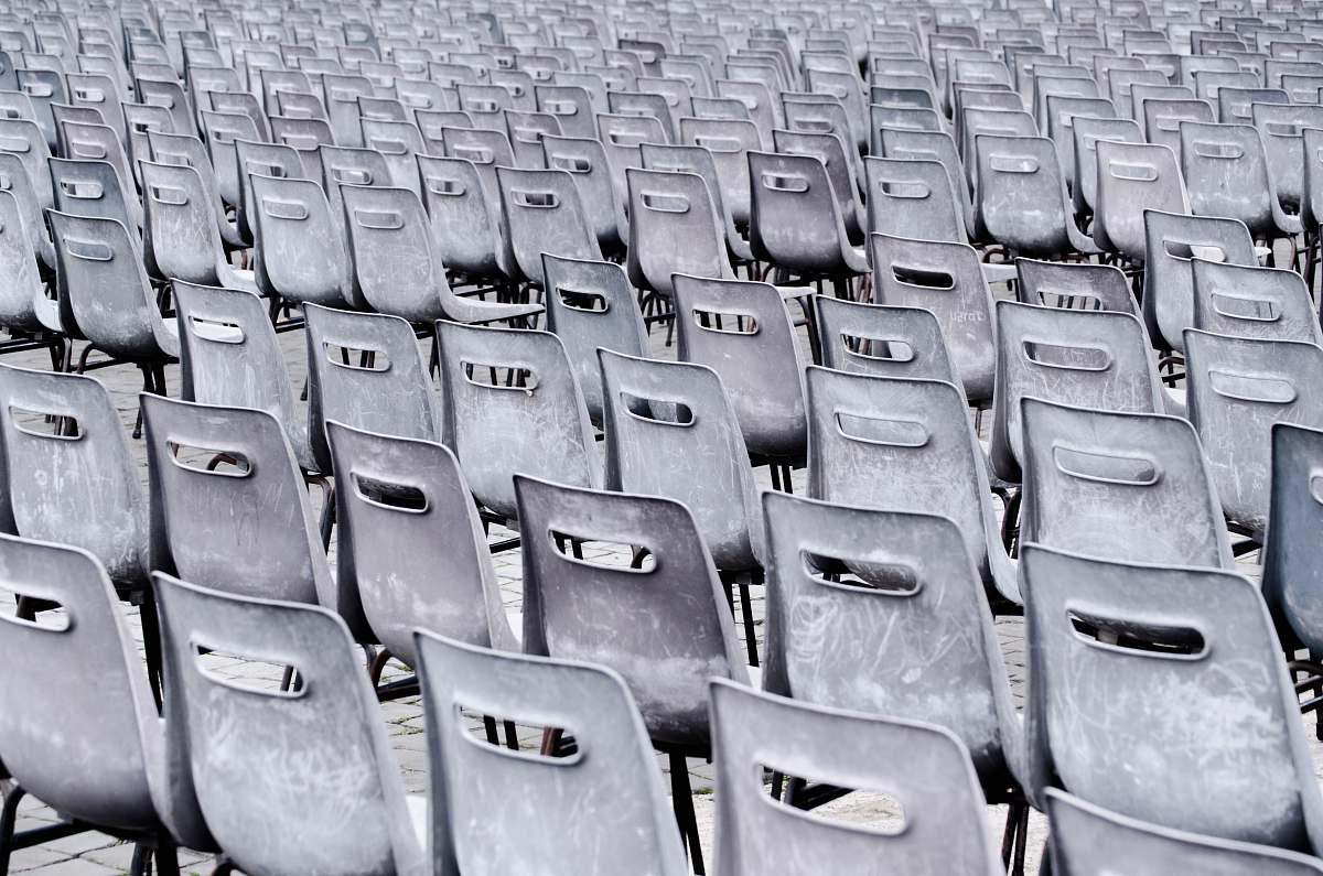 grey gray chairs lined up on pavement italy