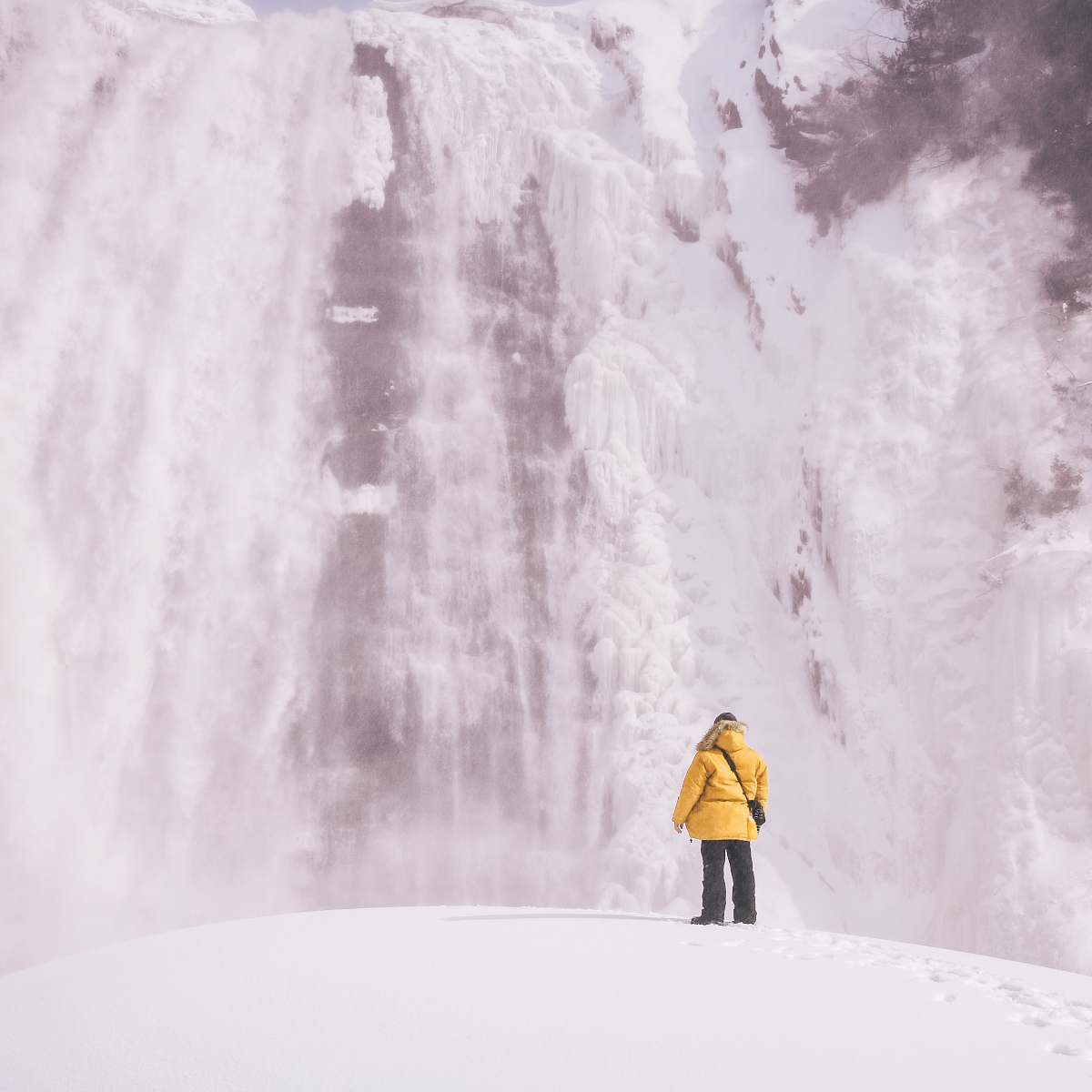 apparel person standing front of waterfalls coat