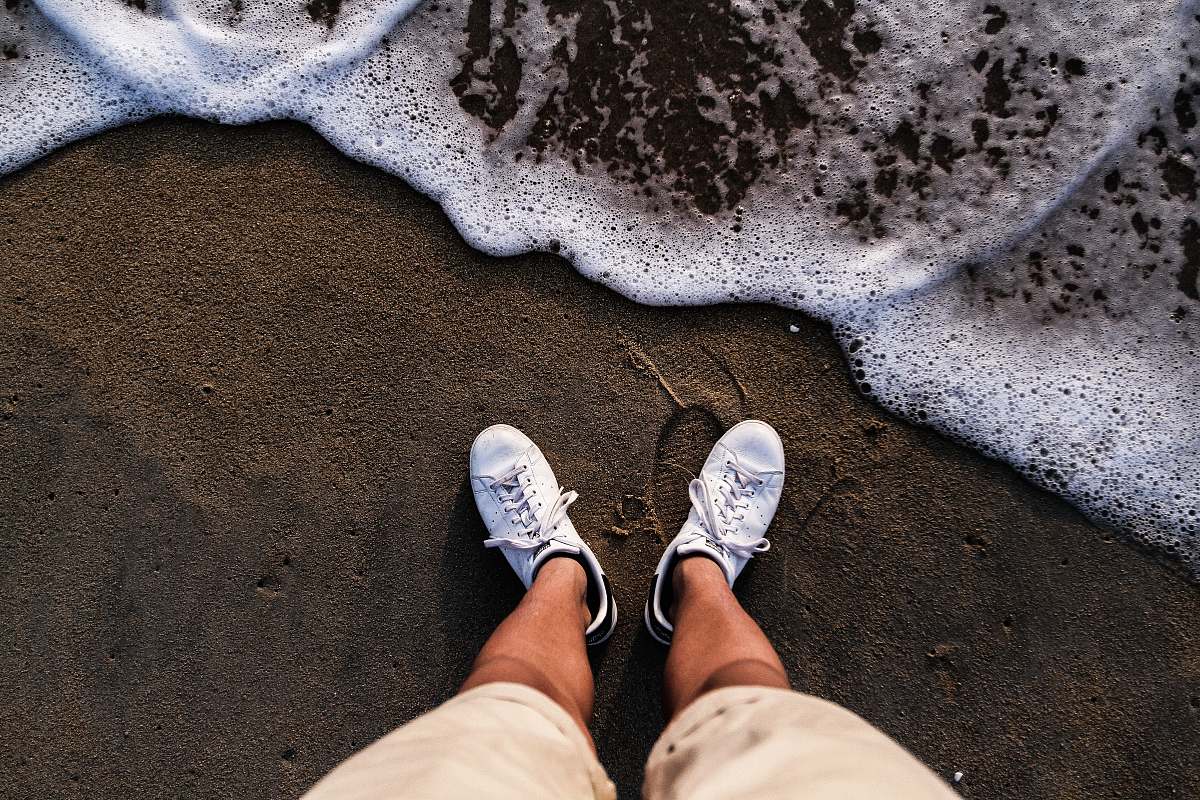 footwear person wearing white shoes standing on sea shore shoe