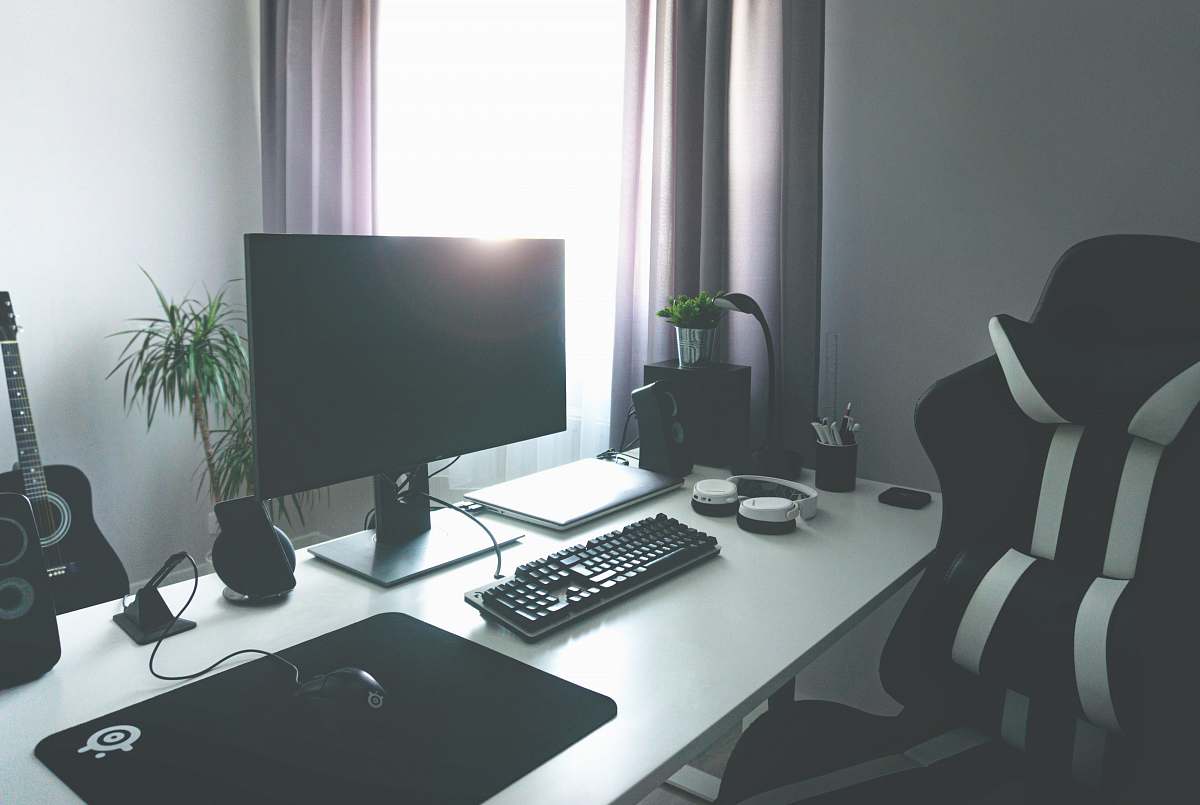 keyboard flat screen monitor turned-off near corded keyboard and mouse on white table beside black and white rolling chair hardware