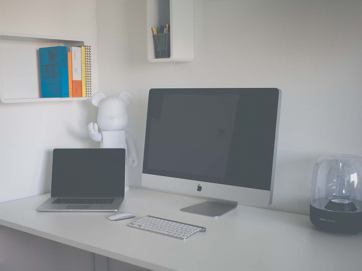 table silver iMac beside MacBook Pro laptop