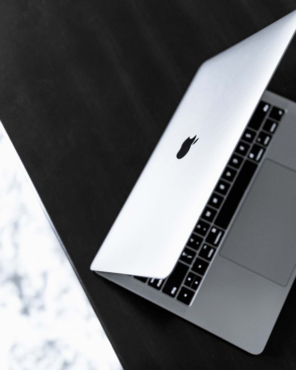 game opened silver MacBook on black wooden surface white