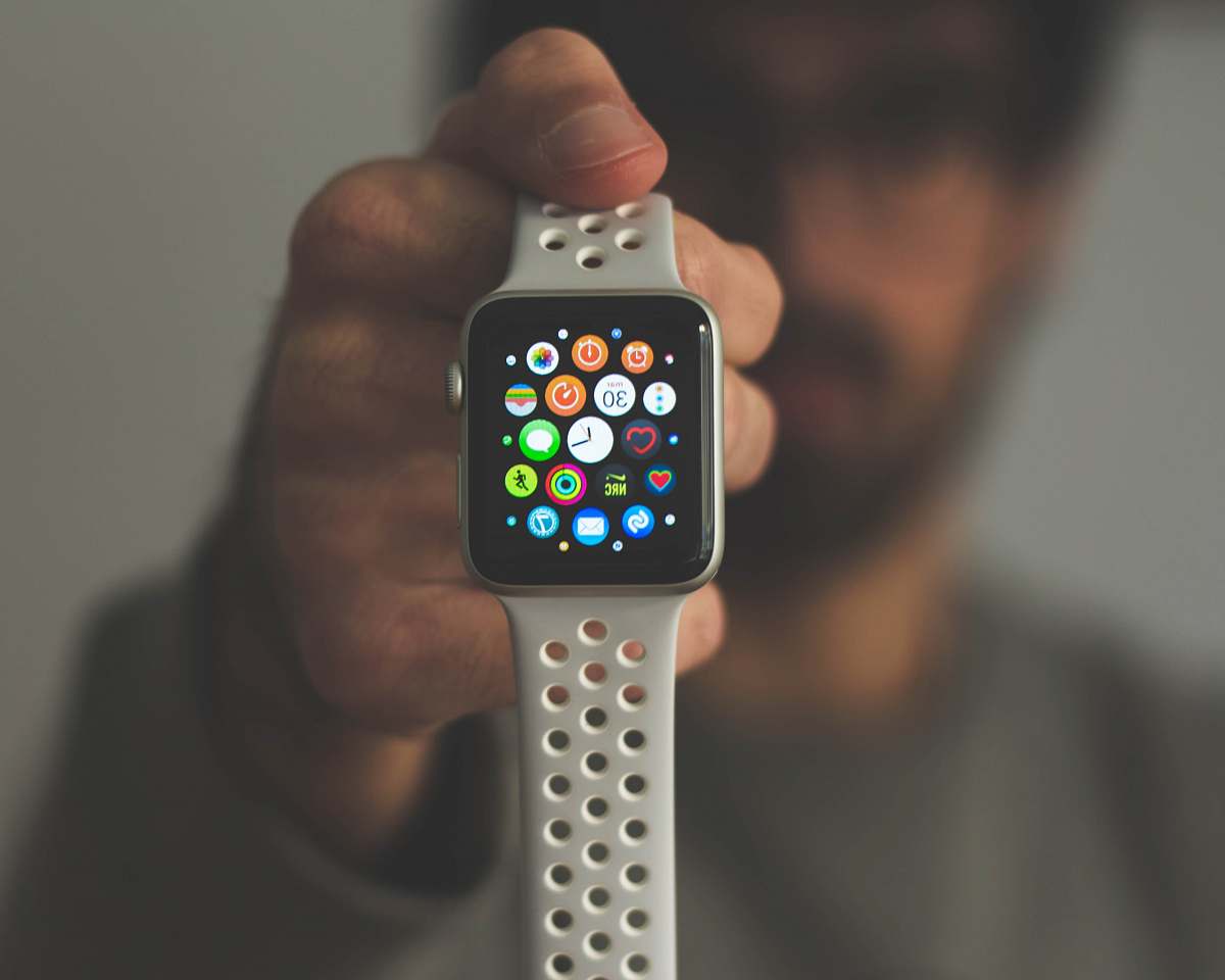 game person holding silver aluminum case Apple Watch iphone