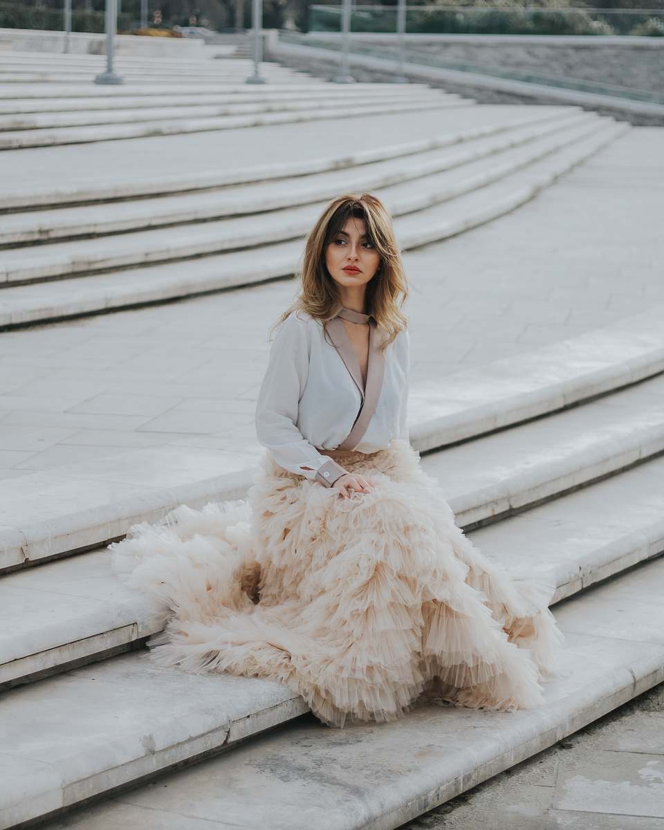 baku brown haired woman in white dress sitting on gray concrete stair during day time azerbaijan