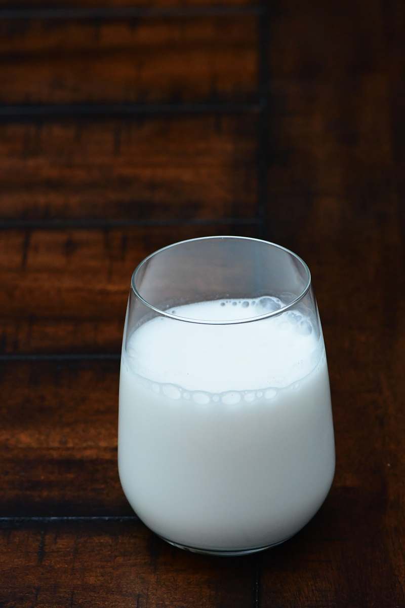 white clear drinking glass with white liquid milk