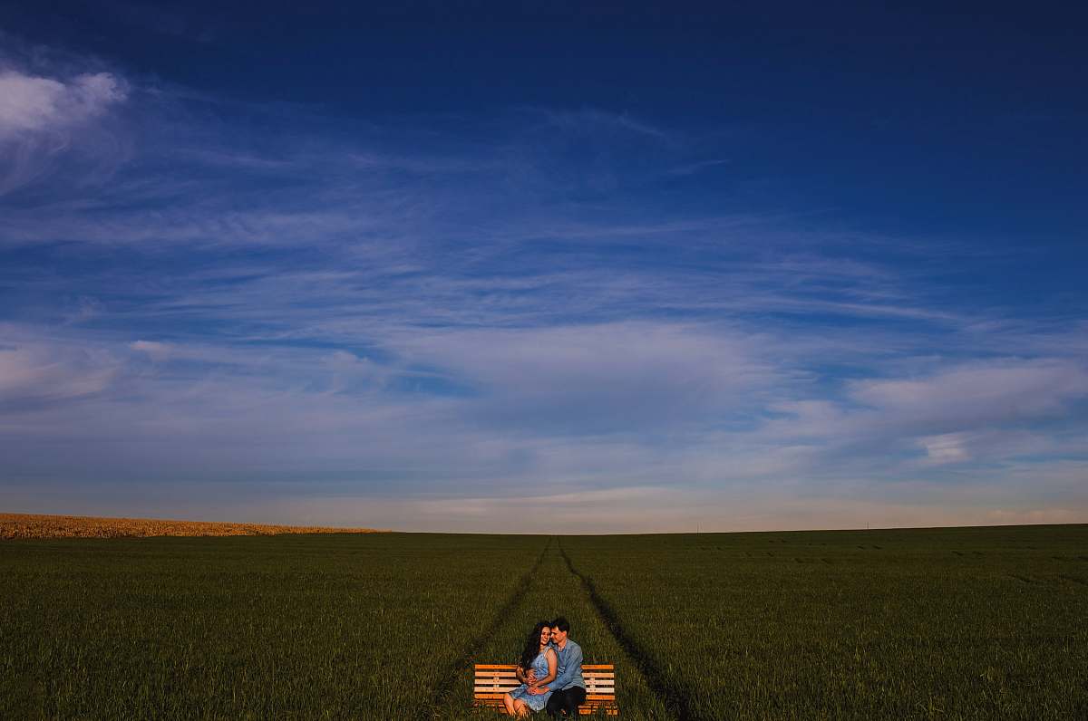 brazil photo of two man and woman sitting on bench on grass field love
