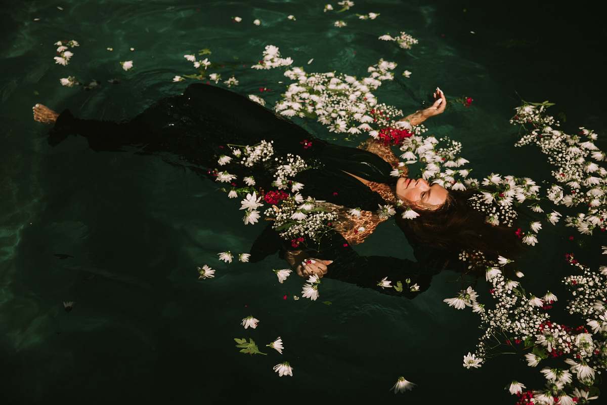 woman woman wearing black suit floats on the water flower