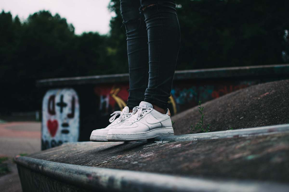 clothing woman standing and wearing white Nike low-top sneakers shoe