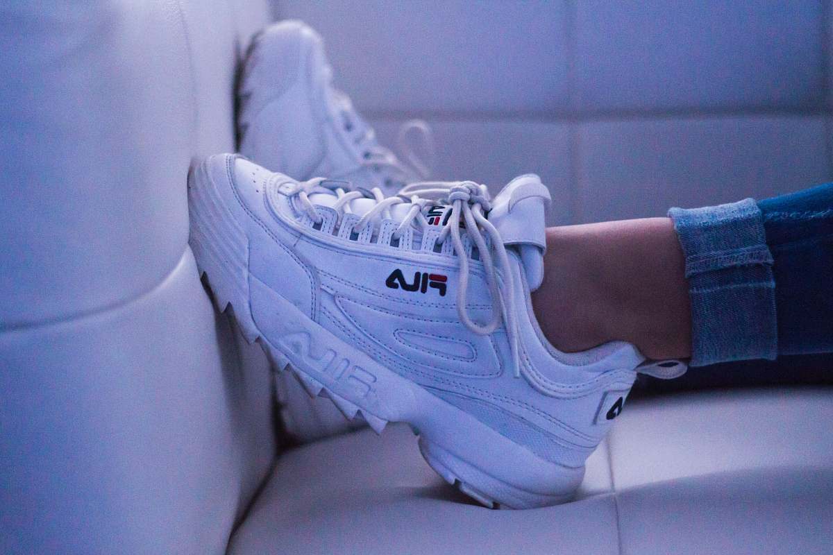 clothing woman wearing white Fila shoes shoe