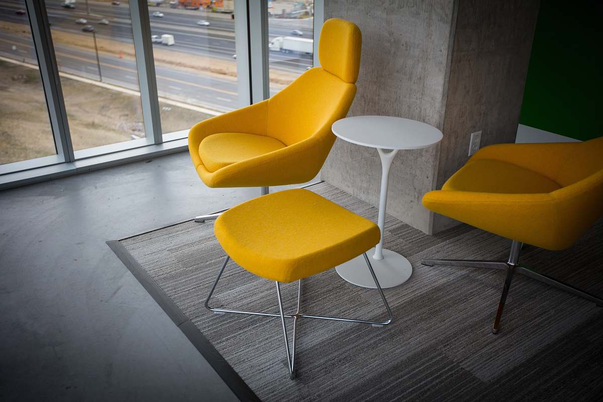 chair room with yellow fabric chairs and ottoman with table yellow