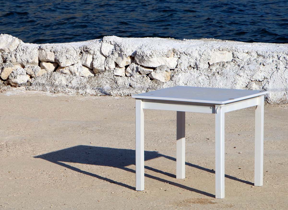 table square white wooden table on dirt ground tabletop