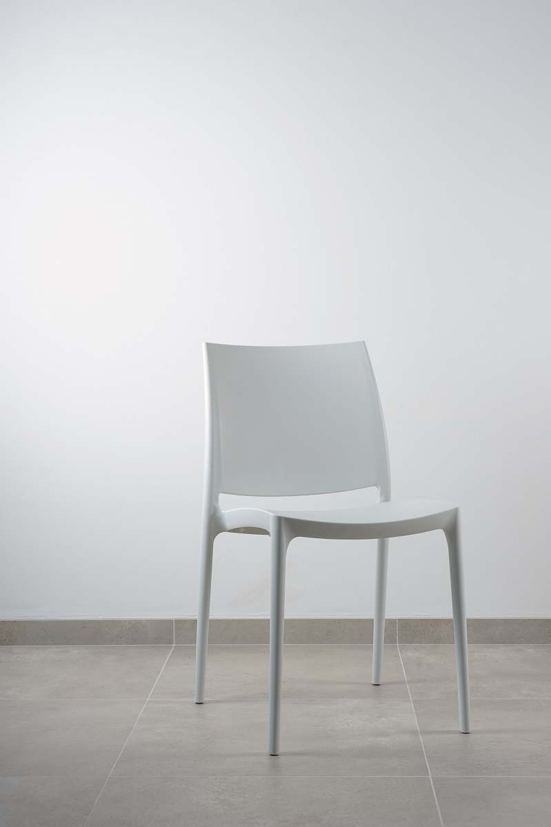 chair white armless chair near white wall blue