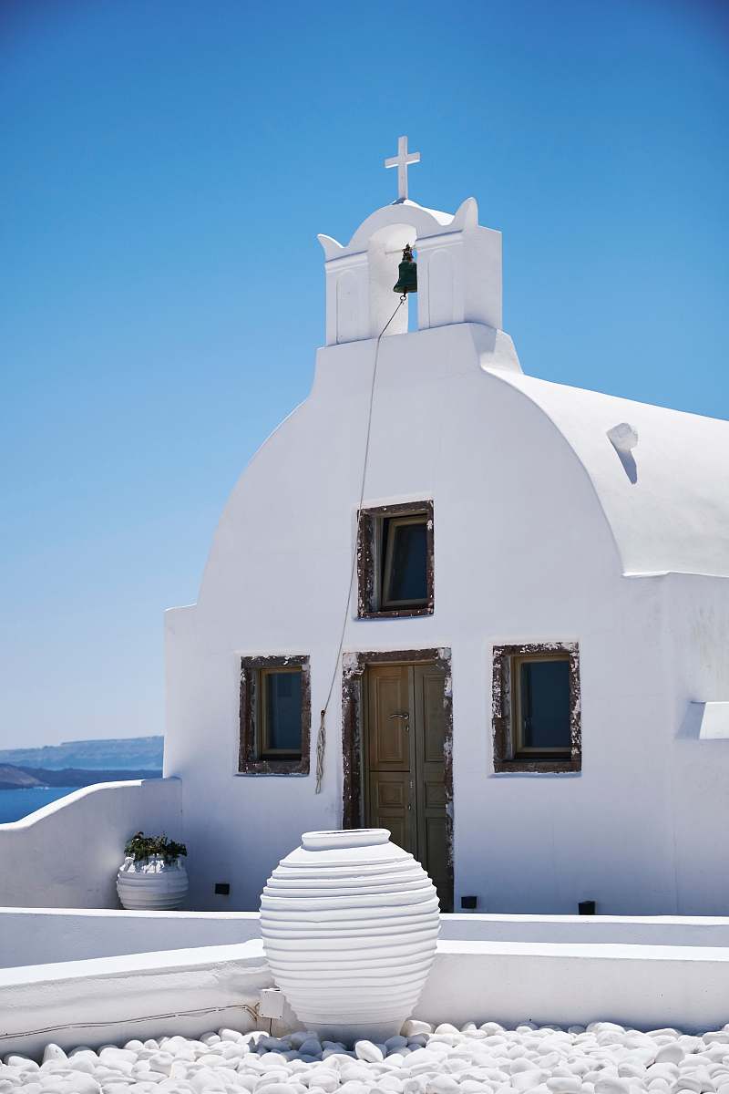 cross white concrete chapel oia