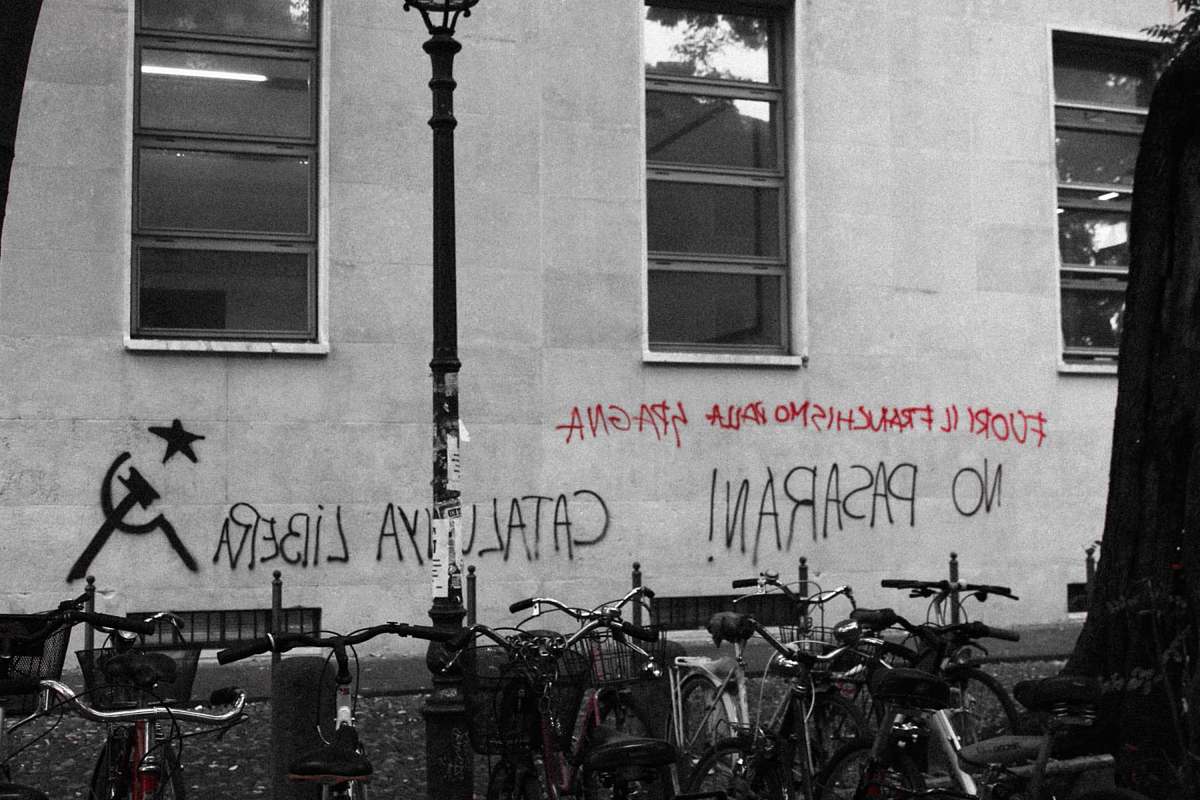 bike black and red text vandals on wall near parked bicycle italy