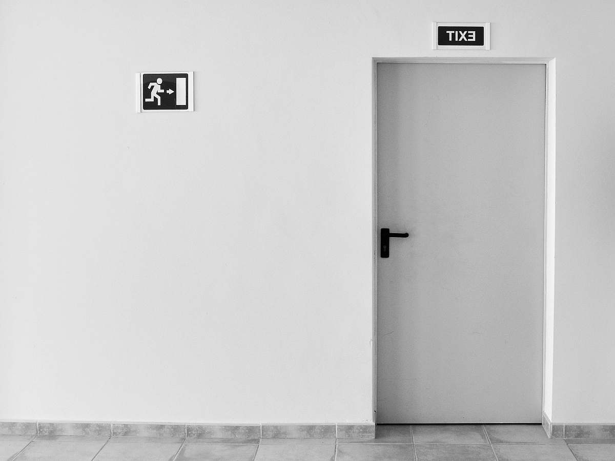 black-and-white closed white painted door with exit signage door