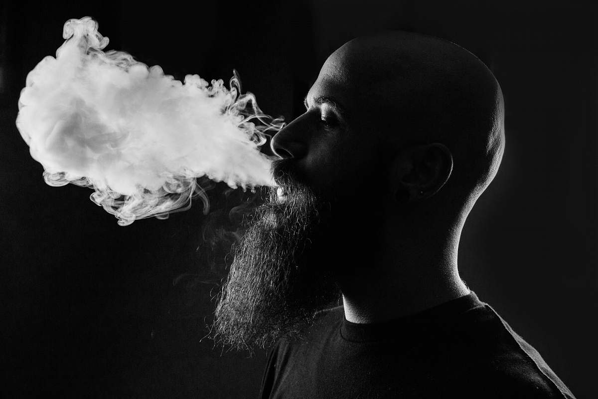 black-and-white man smoking with black background smoke
