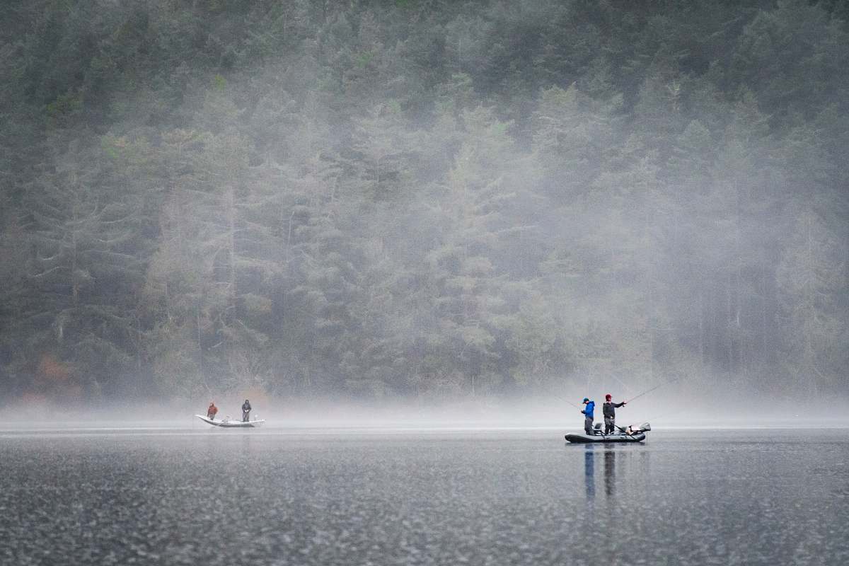 fog people on boat fishing near foggy forest lake campbell