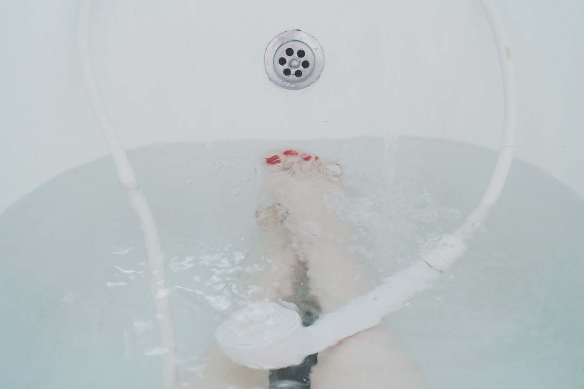 water person sitting in white bathtub bath