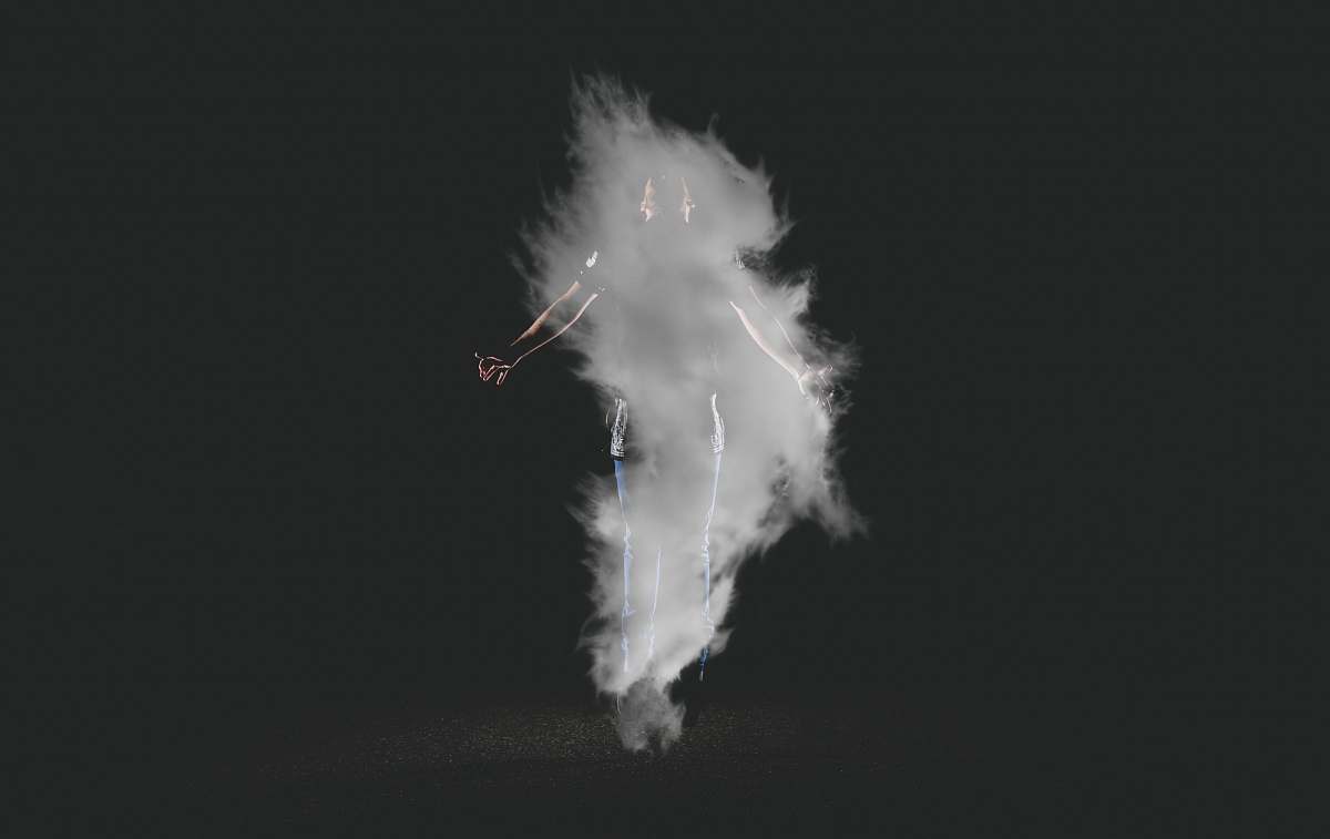 black-and-white person standing near smoke with black background night