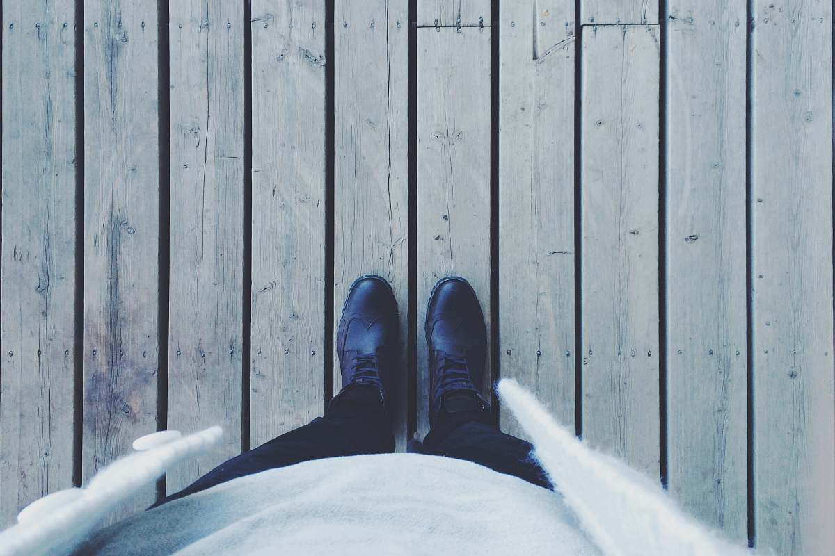 shoes person standing on gray wooden floor standing