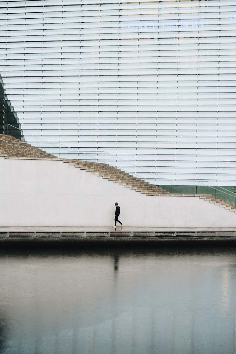berlin person walking beside concrete staircase wall