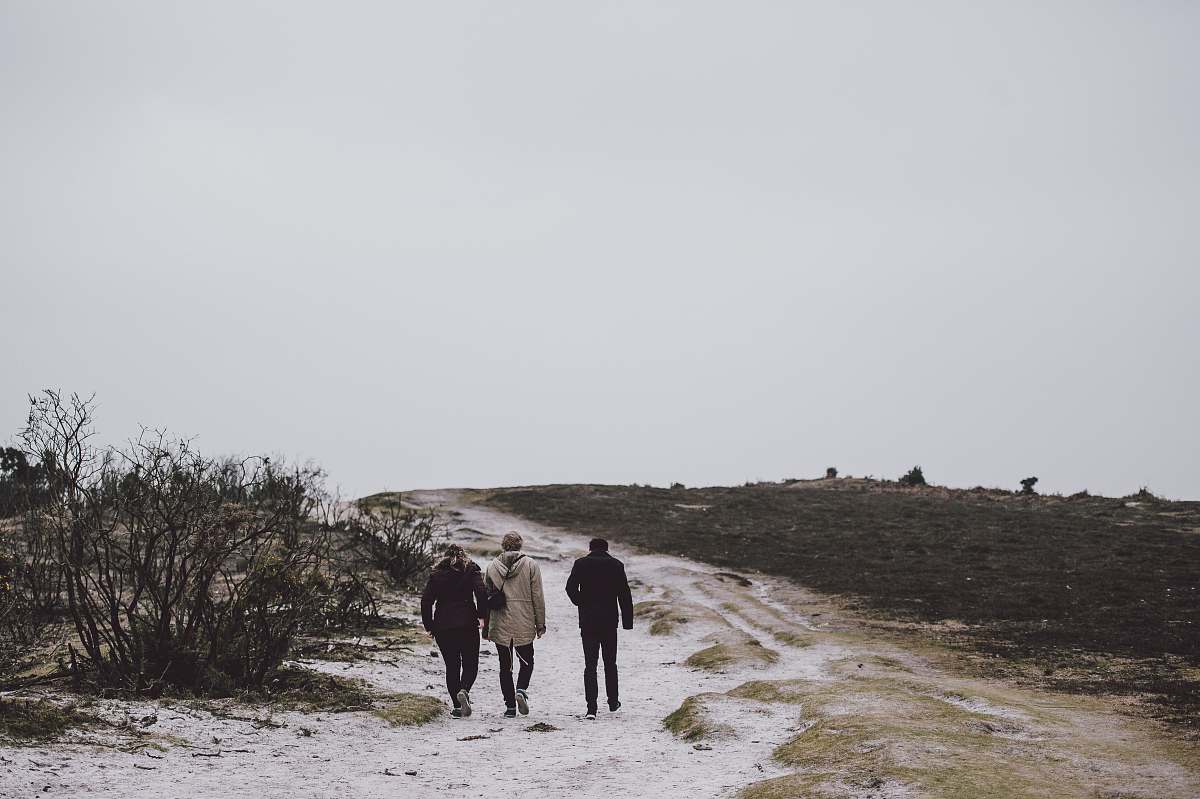 walking three person walking on snow covered field friends