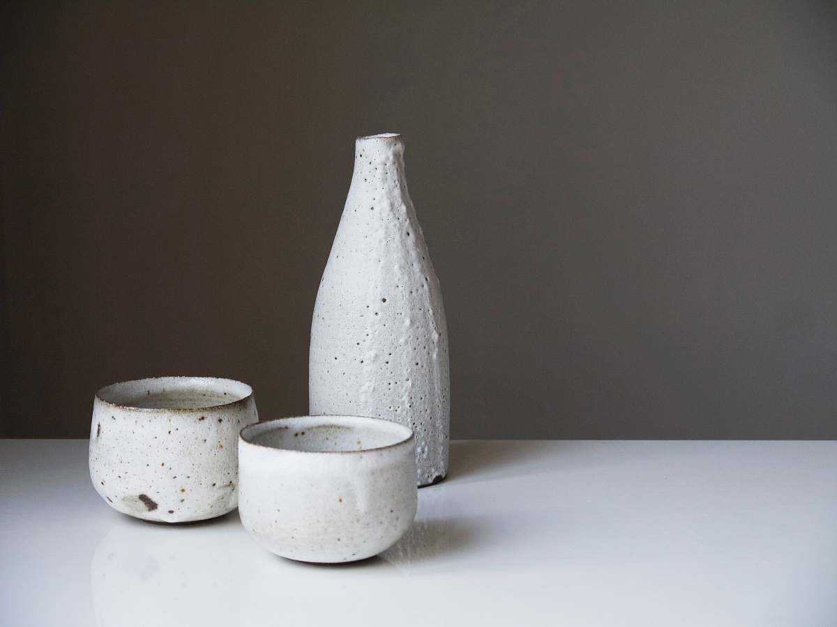 sake two white ceramic bowls and bottle on white table beverage