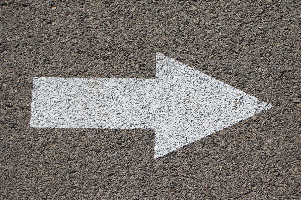 arrow white arrow road sign pavement
