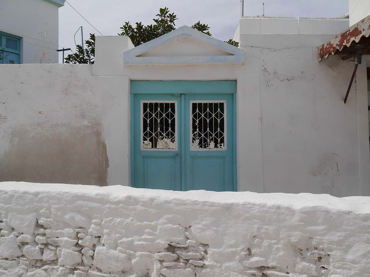 paros white house with blue double-door gate greece