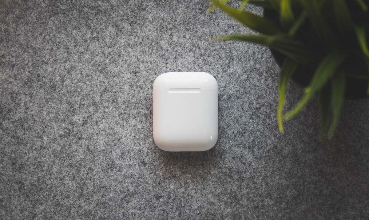airpods white plastic container on table apple