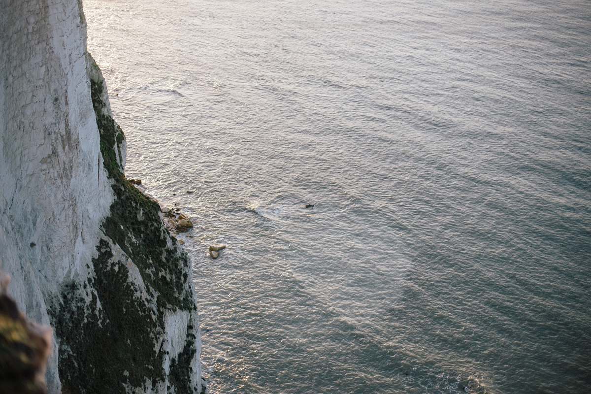 water white rocky mountain next to ocean ripple