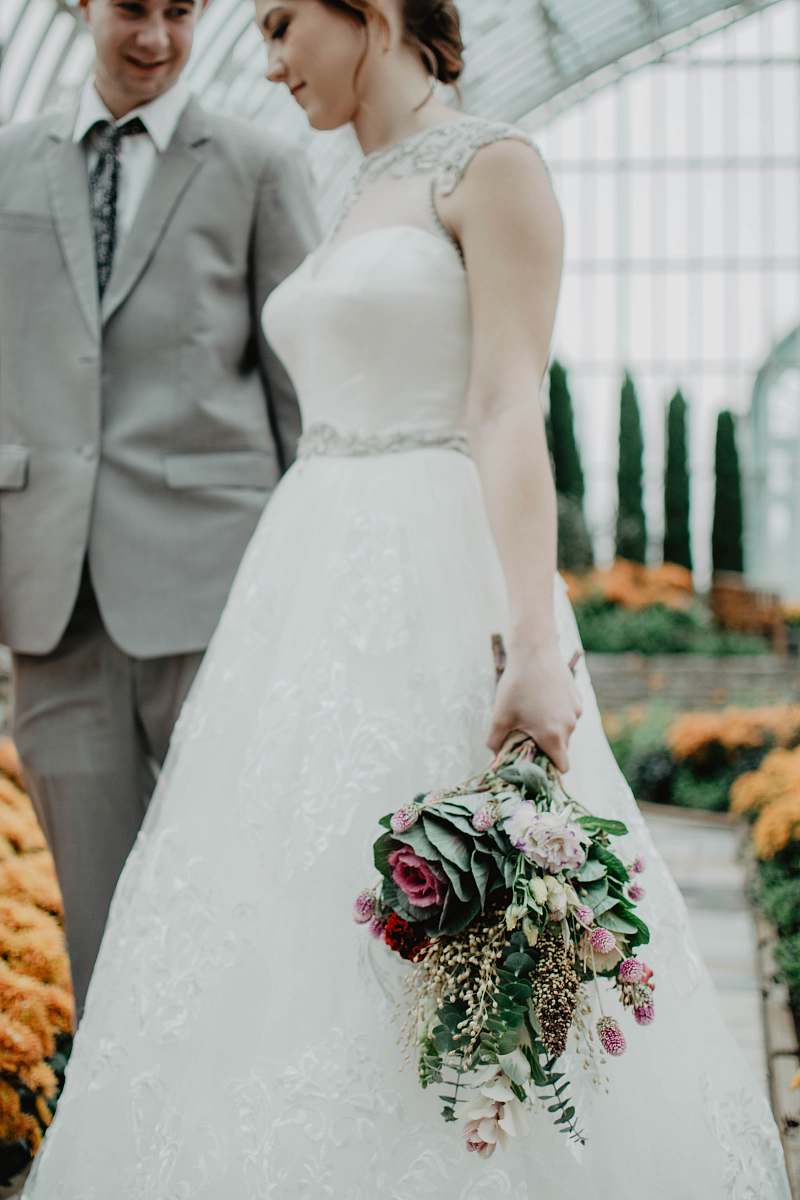 person bride walking with groom on aisle holding flower boquet people
